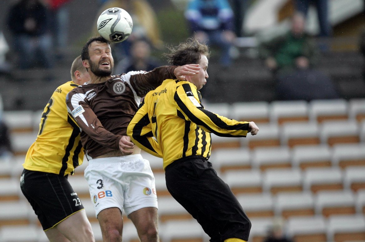 Robert Holmen i duell mot to Harstad-spillere. MIF vant kampen 3-1.